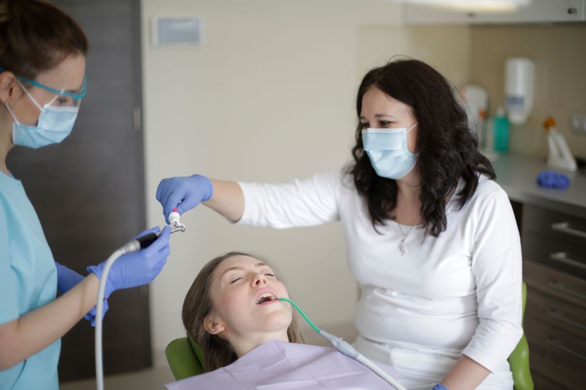 Dental Cleaning treatment detail at Aroma Dental in Humble, TX: a hygienist scaling and polishing a patient's teeth during a professional dental cleaning