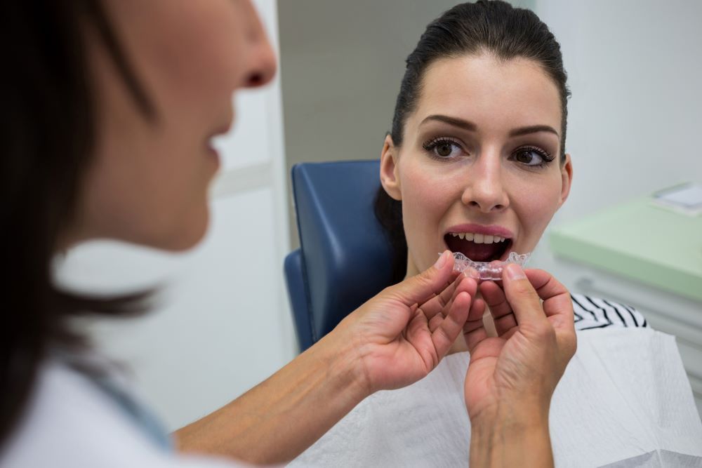 Clear Invisalign aligner tray being placed over teeth in Nobleton, ON