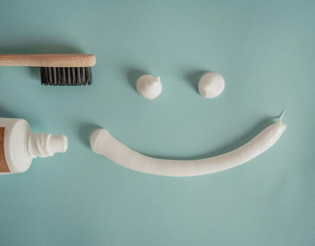 Fluoride Treatment at Aroma Dental in Humble, TX: a hygienist painting professional fluoride varnish onto freshly cleaned teeth