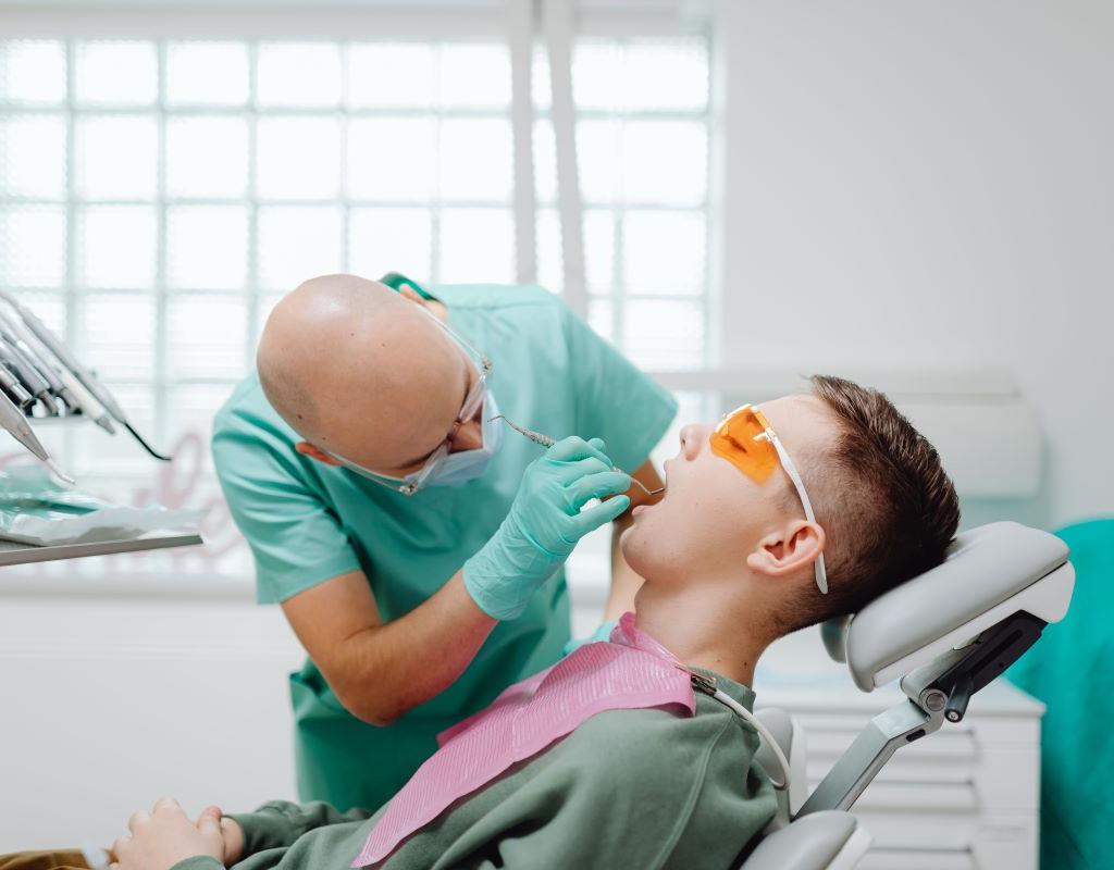 Oral Cancer Screening at Aroma Dental in Humble, TX: a dentist checking a patient's tongue and soft tissues during an oral cancer screening