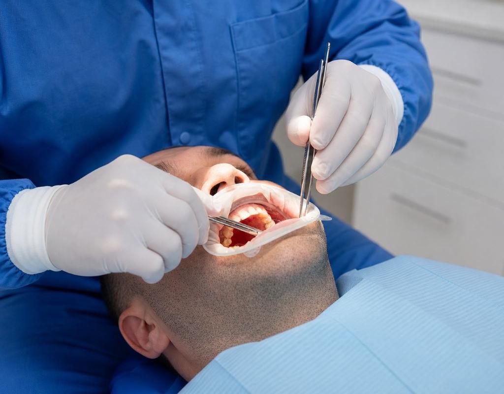 Oral Surgery at Aroma Dental in Humble, TX: an oral surgeon performing a planned surgical procedure in a fully equipped operatory